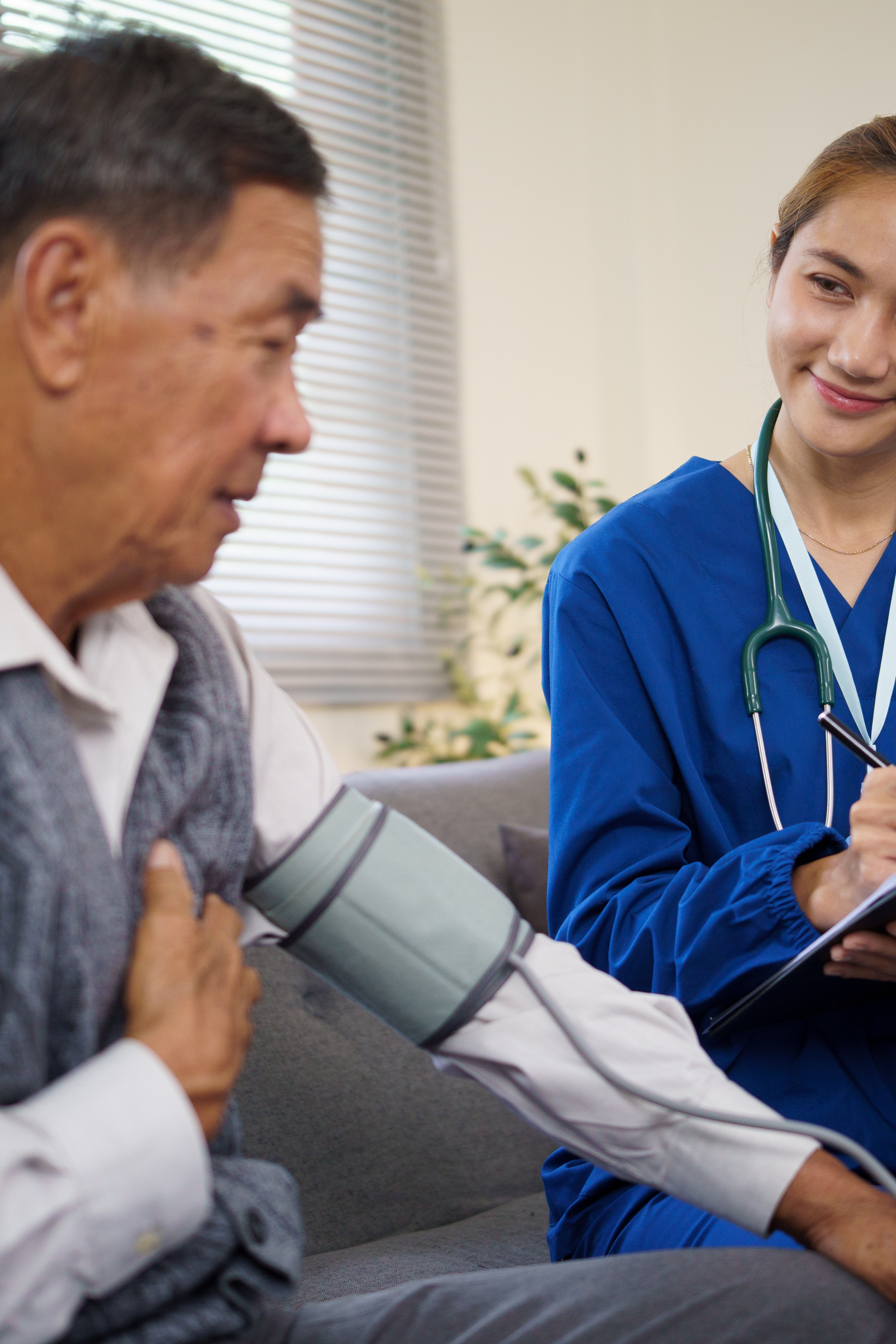 Friendly home health care nurse visiting an older adult at home.